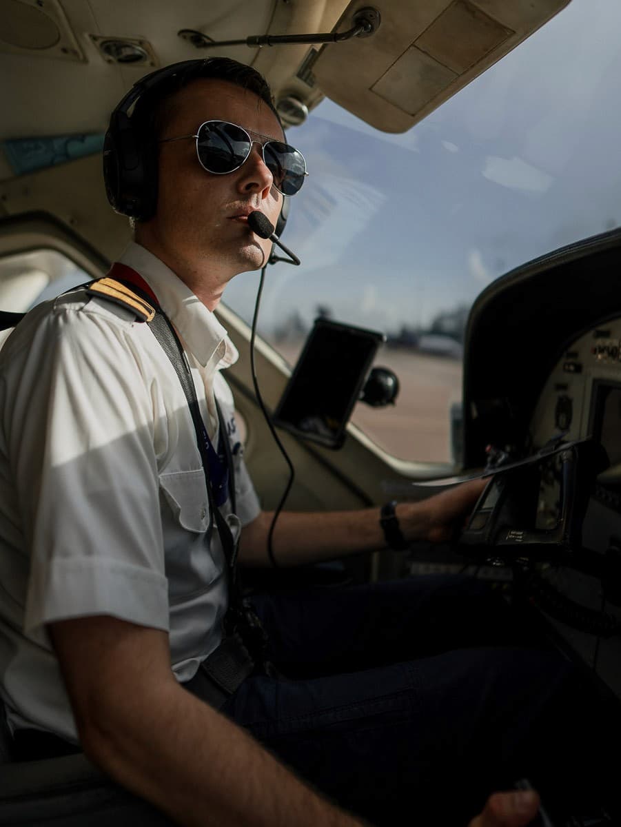 Pilot in a cockpit wearing aviator sunglasses