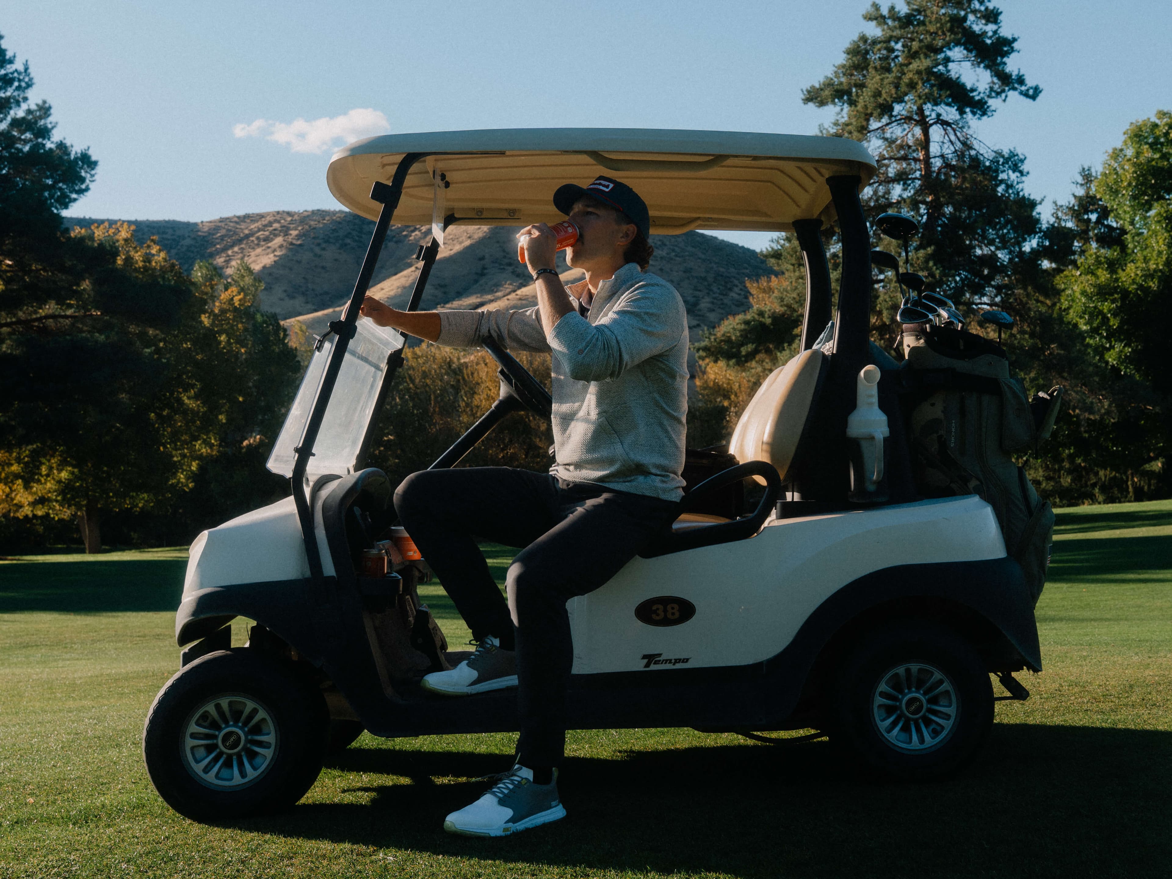 Golfer in a cart on a mountain course